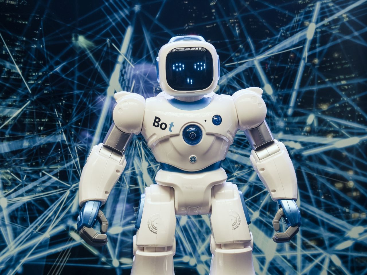 About A modern humanoid robot with luminous features set against a digital network backdrop.